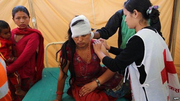 Nepal Red Cross volunteer and nurse Alina Shaestha (R) treating a wounded woman in the village of Chautara in Sindupolchowk.