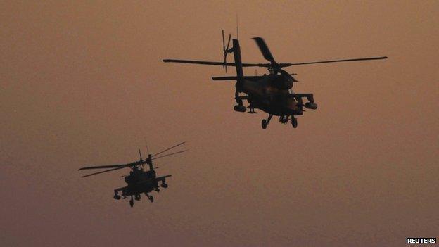 Apache helicopters flying at dusk