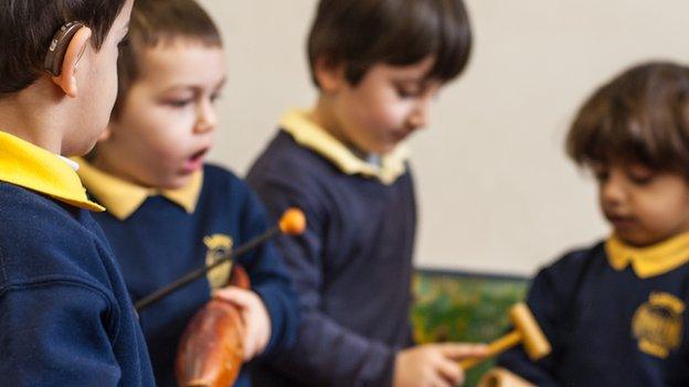 children with hearing aid playing instruments