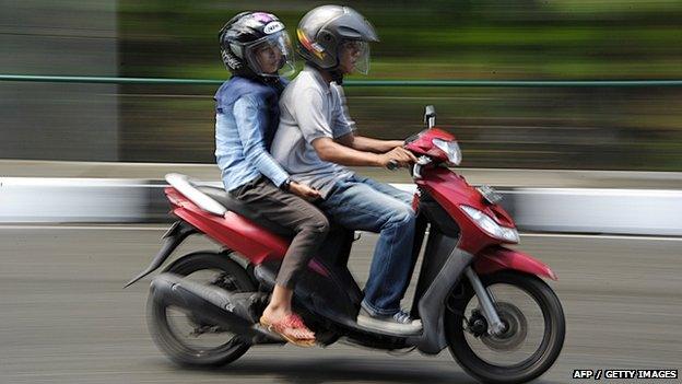 A man and a woman ride a motorbike in Banda Aceh 4 May 2015