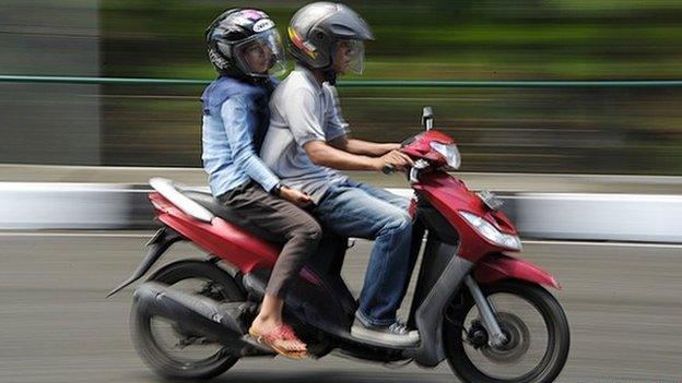 A man and a woman ride a motorbike in Banda Aceh 4 May 2015