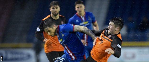 Greg Tansey attempts to hold off John Souttar, the United defender