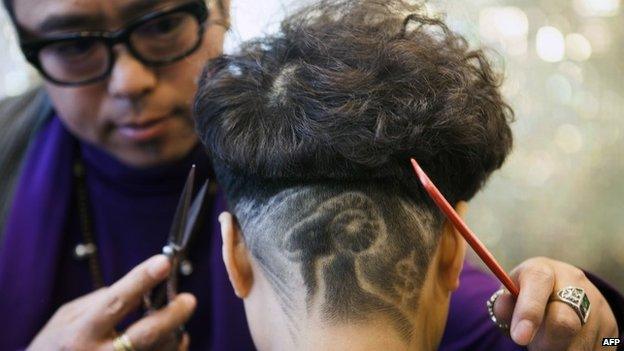 A barber cutting a young man's hair