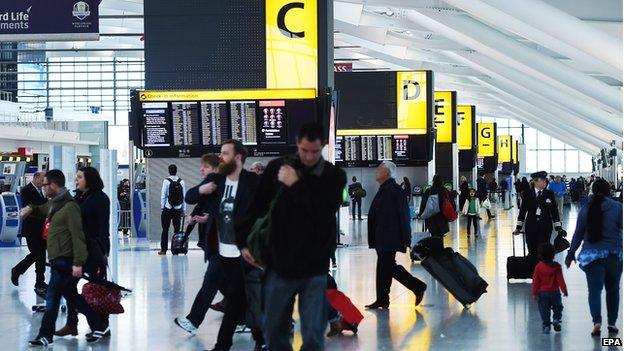 Passengers walk inside Terminal at Heathrow Airport in London on 14 October 2014.