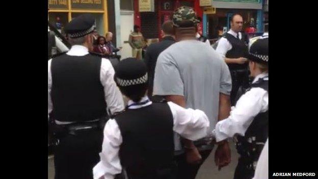 The Metropolitan police lead a man away in handcuffs