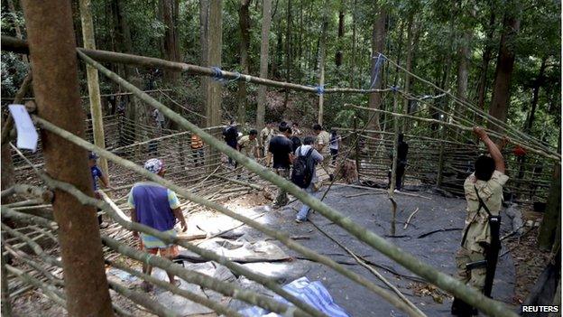 Security forces and rescue workers inspect at abandoned camp in a jungle in Thailand's southern Songkhla province 5 May 2015.