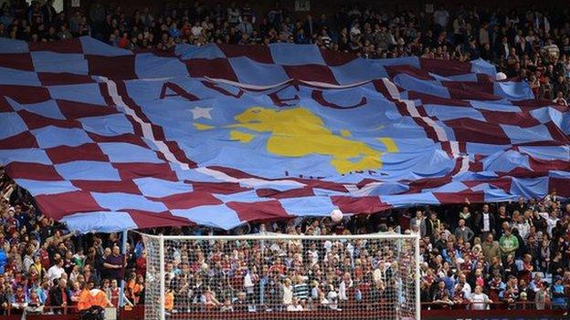 Aston Villa fans hold aloft a flag