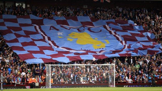 Aston Villa fans hold aloft a flag