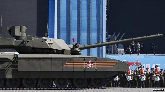 A Russian tank driver holds a red flag in Moscow. Photo: 7 May 2015