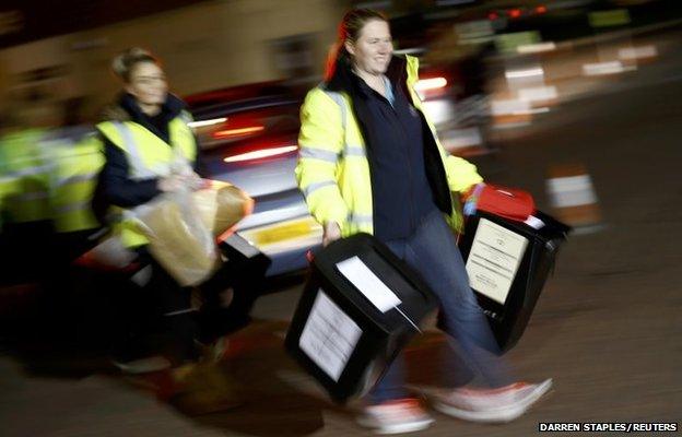 Electoral workers carry ballot boxes from opposition Labour Party leader Ed Miliband's constituency into the counting centre in Doncaster