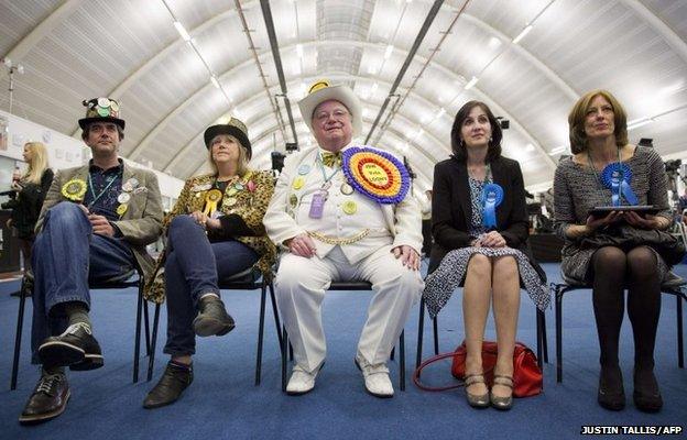 Monster Raving Loony Party candidate for Uxbridge and Ruislip South, Howling Laud Hope (C), watches election results on live television as he waits in the counting centre in Uxbridge