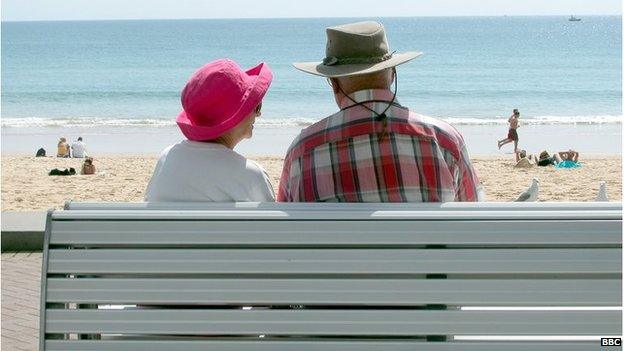 Elderly couple sitting on a bench at the beach