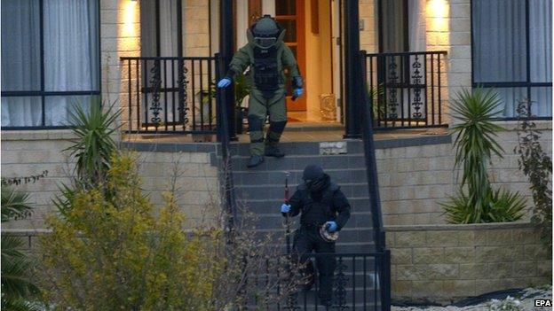 Officers wearing bomb suits raid a home in Greenvale, Melbourne, Australia, 8 May 2015