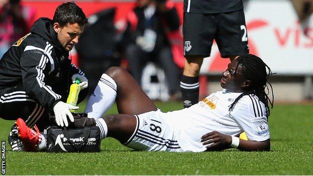 Bafetimbi Gomis (right) receives treatment