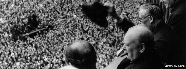 British Prime Minister Winston Churchill (1874 - 1965) waving to crowds gathered in Whitehall on VE Day, 8th May 1945.