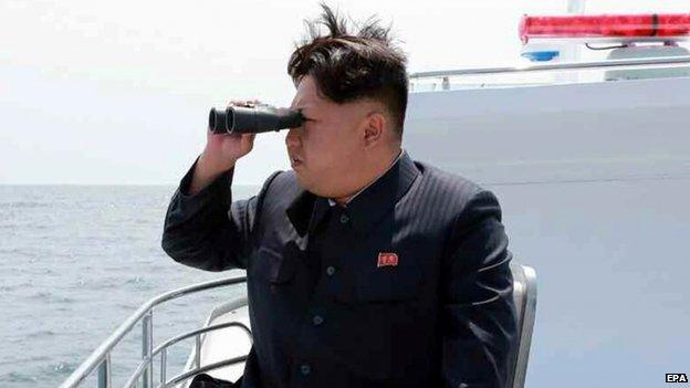 An image obtained by Yonhap News Agency showing North Korean leader Kim Jong-un looking through a pair of binoculars at a ballistic missile (not in frame),