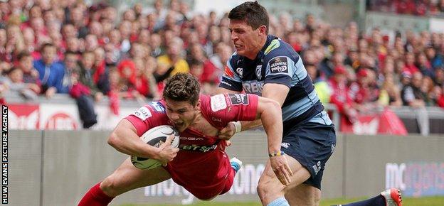 Scarlets wing Harry Robinson is pushed into touch just short of the line by Richard Smith of Cardiff Blues