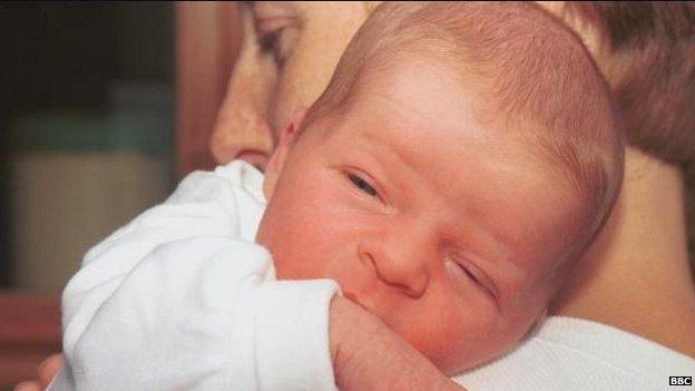 A woman holds a small baby