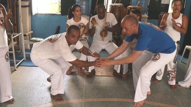 Doedd dim angen pâr da o 'sgidiau ar Jason i fynd i'r afael â 'capoeira' ar ei deithiau gyda'r BBC yn Brasil