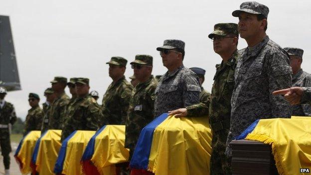 Colombian Army soldiers stand next to the coffins with the remains of the 11 soldiers who died in a Farc attack. Picture from 16 April 2015.