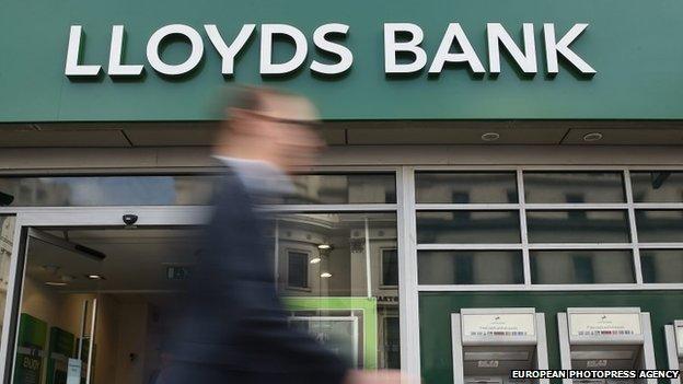 A man walks past a Lloyds bank branch