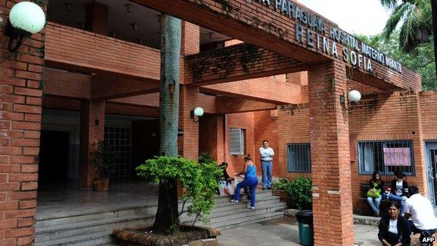 People remain at the entrance of the Red Cross Hospital where a 10-year-old pregnant girl is being treated in Asuncion on 8 May, 2015.