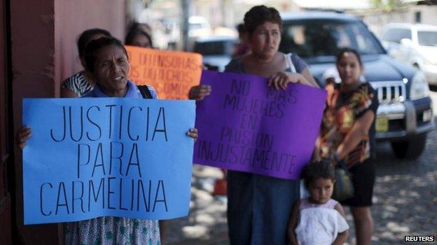 Women hold banners in support of Honduran domestic worker Carmelina Lopez Alvarado during a hearing in La Union on 16 April, 2015.