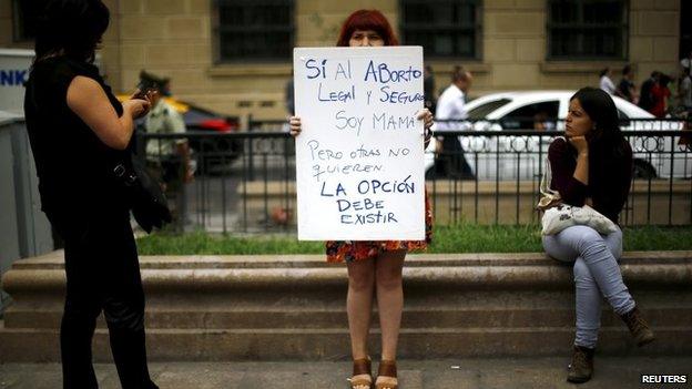 A woman holds up a pro-choice banner in Santiago on 23 March, 2015