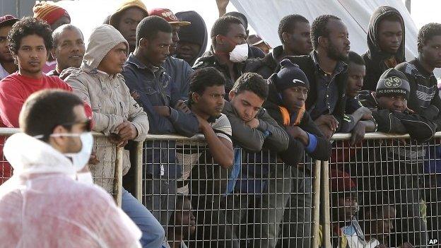 Migrants wait to disembark from the Iceland Coast Guard vessel Tyr, at the Messina harbor, Sicily, southern Italy