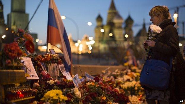 Woman lays a bunch of flowers where Boris Nemtsov died (7 April)