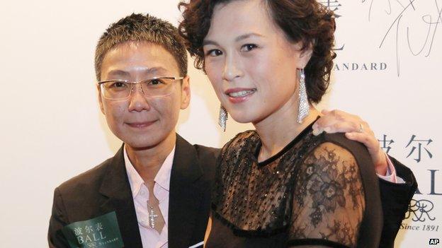 In this undated photo, Gigi Chao, right, daughter of the Hong Kong property tycoon Cecil Chao, poses with her partner Sean Eav at an event in Hong Kong