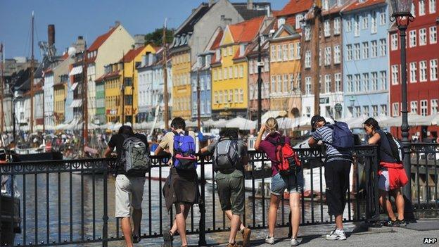 Tourists leaning on railings overlooking the water in Copenhagen