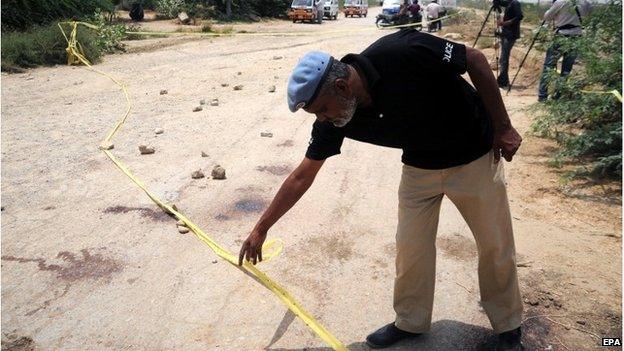 Pakistani security officials inspect the site