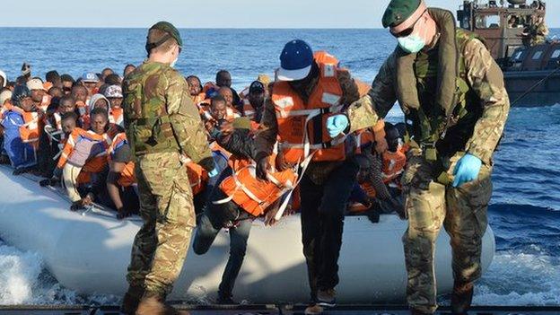 Royal Marines lead migrants to safety on HMS Bulwark's landing craft