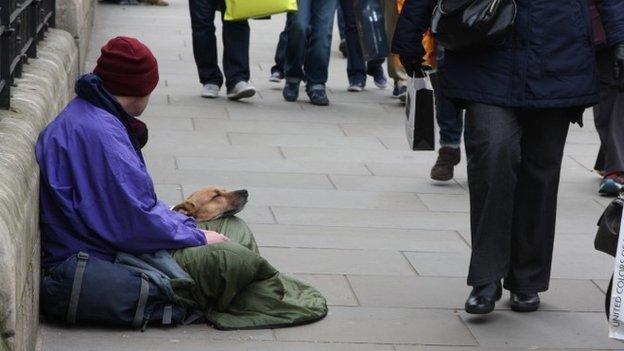 Homeless man sat on a London street with his dog. 01/04/2015. road. wealth gap. rich and poor. Begger. Homelessness.