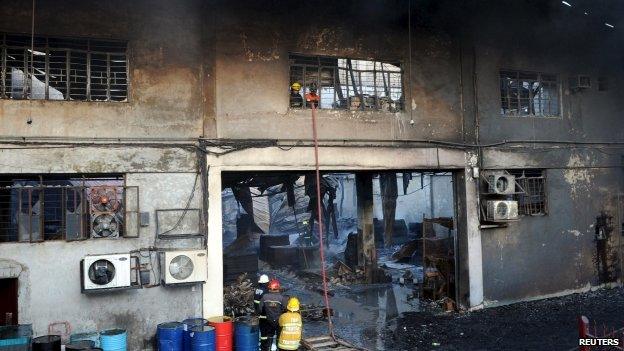 Firemen and rescuers look for the victims trapped in a fire at a factory in Valenzuela, Metro Manila in the Philippines May 13, 2015