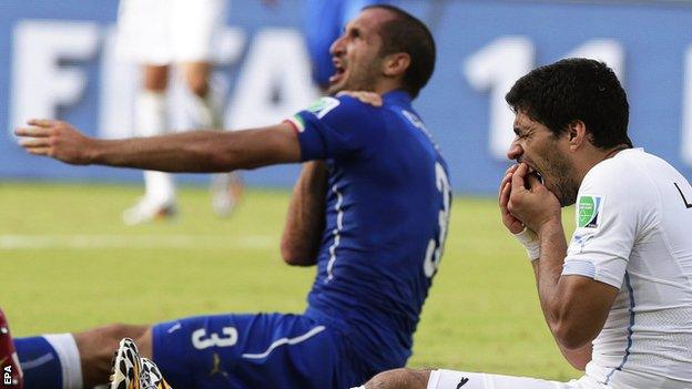 Luis Suarez holds his mouth after clashing with Girgio Chiellini