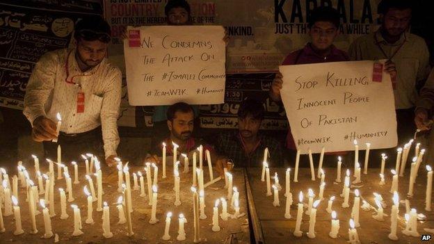 People light candles to protest and show solidarity with the victims of a bus attack in Karachi, Pakistan, Wednesday, May 13, 2015.