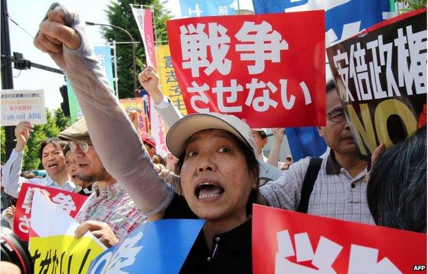 Activists shout slogans against Japanese Prime Minister Shinzo Abe as some 500 protestors gather in front of the prime minister's official residence in Tokyo on 14 May 2015.