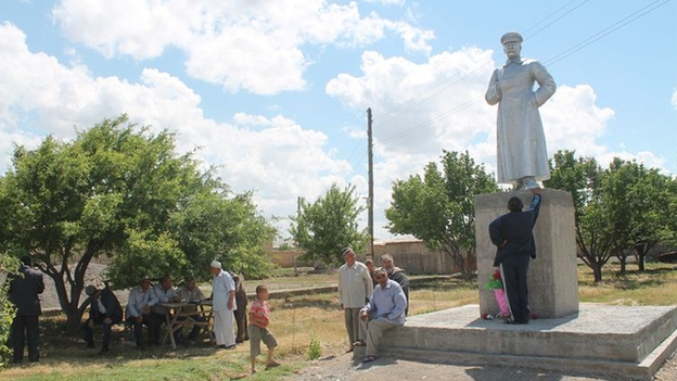 Villagers gathering around the Stalin statue