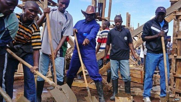 Burundi's President, Pierre Nkurunziza (C) helps on the construction site of a school in the province of Ngozi in northern Burundi on September 12, 2013