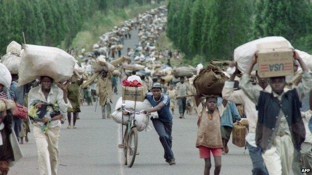 Tens of thousands of Rwandan Hutu refugees carry their belongings as they flee towards the Tanzanian border from the refugee camps at Magara, near the northern Burundian town of Ngozi on 31 March 1995