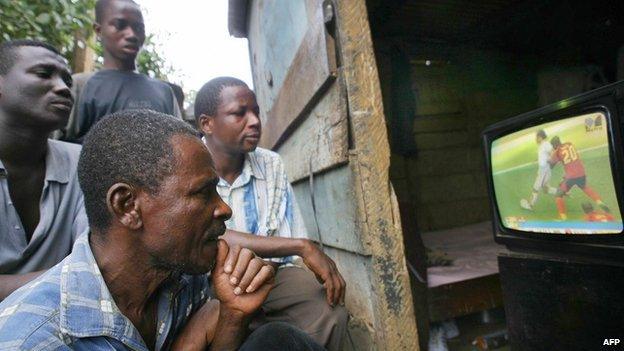 Accra, GHANA: Ghanaians watch a tv sporting the Angola versus Iran world cup football match 21 June 2006 in their room in a poor area of Accra.