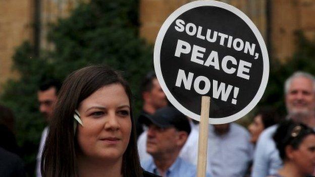 A woman holds a placard during a demonstration in favour of a peace settlement on divided Cyprus in Nicosia, 11 May 2015.