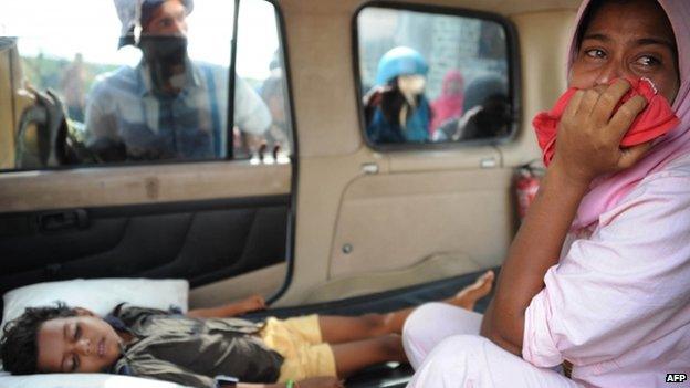 A migrant Rohingya woman (right) from Myanmar cries as she waits for an ambulance to evacuate her sick child from the Kuala Cangkoi relocation area in Aceh province, Indonesia (14 May 2015)