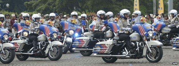 Female members of the Indonesian police force ride motorbikes as they mark Kartini Day in Jakarta on April 22, 2013.