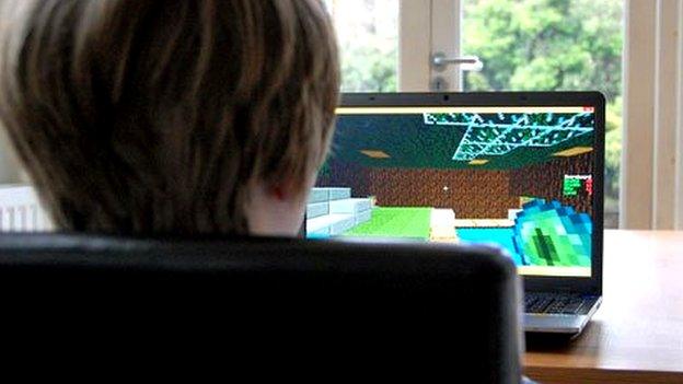 Boy plays Minecraft at kitchen table