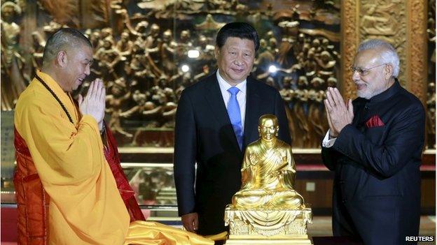 Chinese President Xi Jinping (C) looks on as Indian Prime Minister Narendra Modi (R) receives a golden Buddha statue from a Buddhist abbot of Dacien Buddhist Temple in Xian, Shaanxi province, China, 14 May 2015.