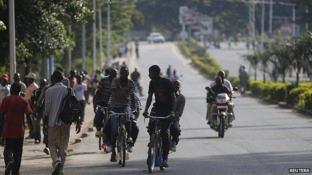 People ride bicycles in a street in Bujumbura, Burundi, on 15 May 2015.