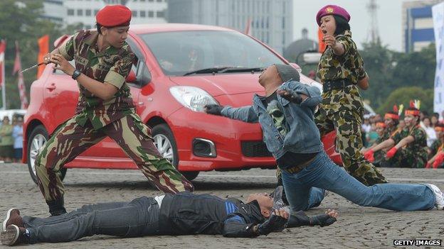 A female member of the Indonesian Special Army Forces and Marines show their martial arts skills in Jakarta on April 22, 2013